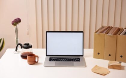 A minimalist workspace featuring a laptop, folder organizers, and coffee, ideal for productivity.